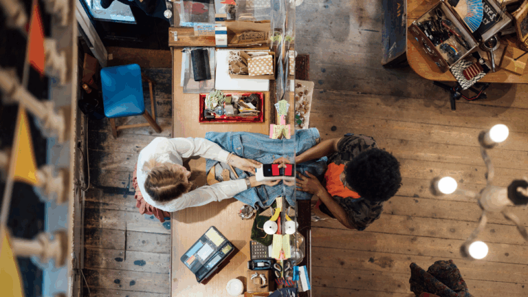 Women sitting across from one another doing a project together