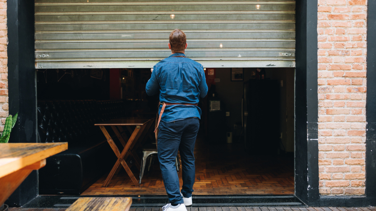 A man in an apron closing a garage door