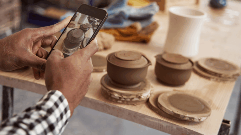 Someone taking a photo of pottery with their phone