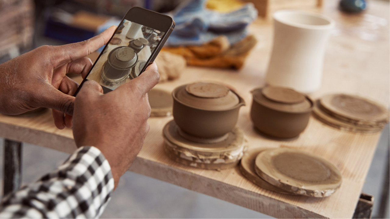 Someone taking a photo of pottery with their phone